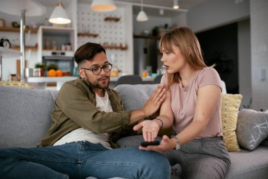 Erkek arkadaşı ve kız arkadaşı kanepede tartışıyor. Kızgın kadın erkek arkadaşına bağırıyor..