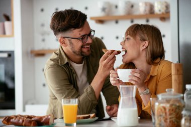 Genç çift evde lezzetli yemekler yapıyor. Sevgi dolu çift mutfakta eğleniyor..