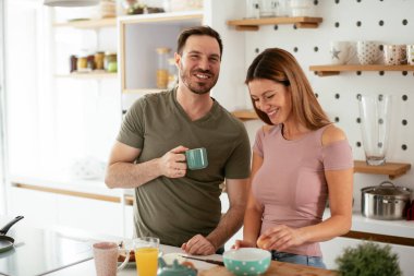 Mutlu çift mutfakta kahvaltı yapıyor. 