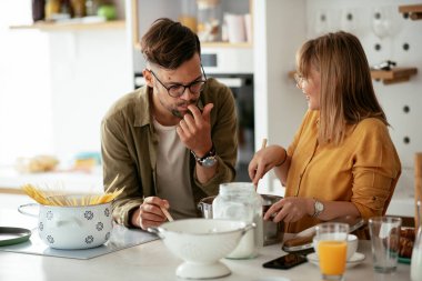 Karı koca mutfakta. Genç çift evde lezzetli yemekler hazırlıyor..