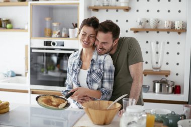 Genç çift evde krep yapıyor. Sevgili çift yemek yaparken eğleniyor..