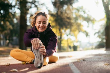 Genç atletik kadın parkta kendini geriyor. Güzel bir sporcunun portresi..