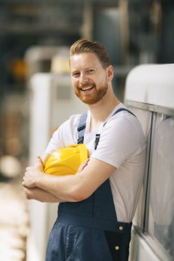 Fabrika işçisinin portresi. Genç yakışıklı fabrika işçisi.
