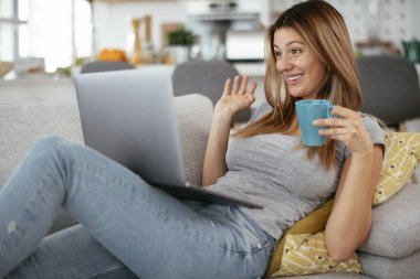 Güzel bir kadın görüntülü görüşme yapıyor. Genç mutlu kadın evde eğleniyor..