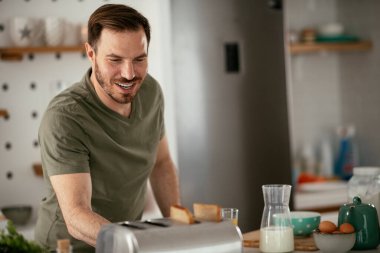 Adam mutfakta kahvaltı yapıyor.