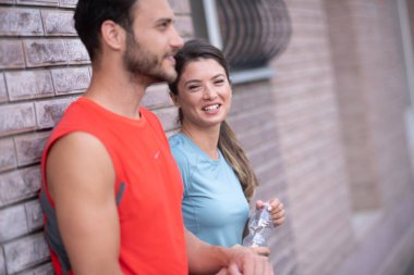Atletik çift şehirde koştuktan sonra dinleniyor. Mutlu çift sabahları eğleniyor...