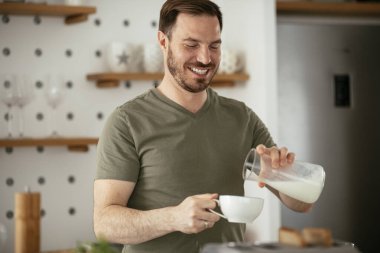 Adam mutfakta kahvaltı yapıyor.