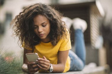 Sokakta telefonla konuşan melez bir kız.