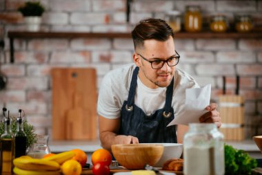 Mutfakta makarna hazırlayan yakışıklı adam. Lezzetli yemek pişiren adam..