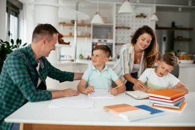 Ebeveynler çocuklara ev ödevlerinde yardım ediyorlar. Küçük çocuklar evde öğreniyor..