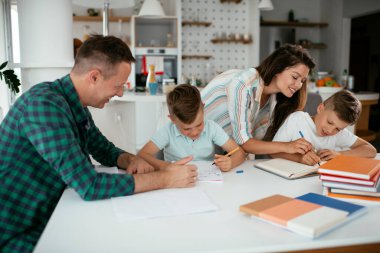 Ebeveynler çocuklara ev ödevlerinde yardım ediyorlar. Küçük çocuklar evde öğreniyor..