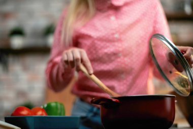 Genç bir kadın yemek yapıyor. Mutfakta güzel bir kadın..