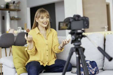 Kadın video kaydedicisi, kanalı için makyaj dersi kaydediyor. Sosyal medyada paylaşmak için makyaj dersi alan genç ve güzel bir kadın..