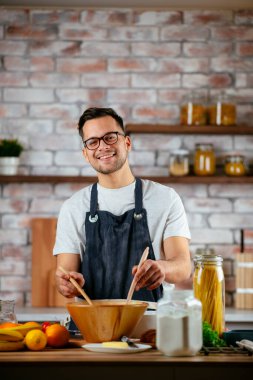 Mutfakta makarna hazırlayan yakışıklı adam. Lezzetli yemek pişiren adam..
