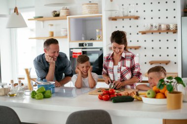 Evde genç ve mutlu bir aile yemeği. Annem ve babam oğullarımla kahvaltı hazırlıyorlar..