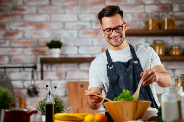 Mutfakta makarna hazırlayan yakışıklı adam. Lezzetli yemek pişiren adam..