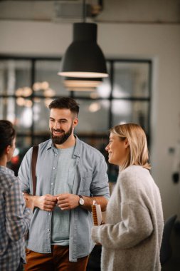 Modern açık uzay ofisinde sıradan iş adamlarından oluşan bir grup. İş kadınları ve işadamları yeni proje hakkında konuşuyor.