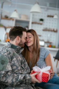 Asker bir hediyeyle karısına sürpriz yapıyor. Genç adam kız arkadaşına hediye kutusu veriyor...