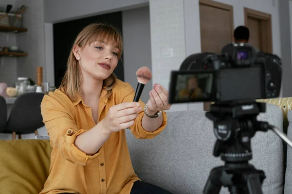 Kadın video kaydedicisi, kanalı için makyaj dersi kaydediyor. Sosyal medyada paylaşmak için makyaj dersi alan genç ve güzel bir kadın..