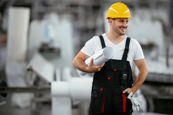 Factory worker with blueprint working on a new project