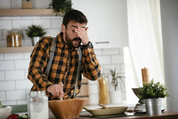 Portrait of handsome man in kitchen. Young man preparing delicious food.