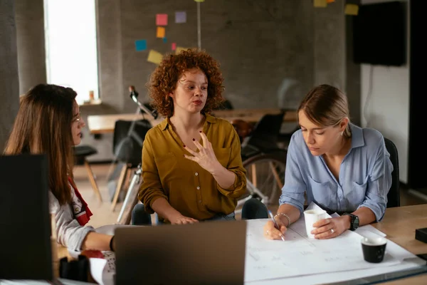 Businesswomen working on a new project. Colleagues discussing work in office.