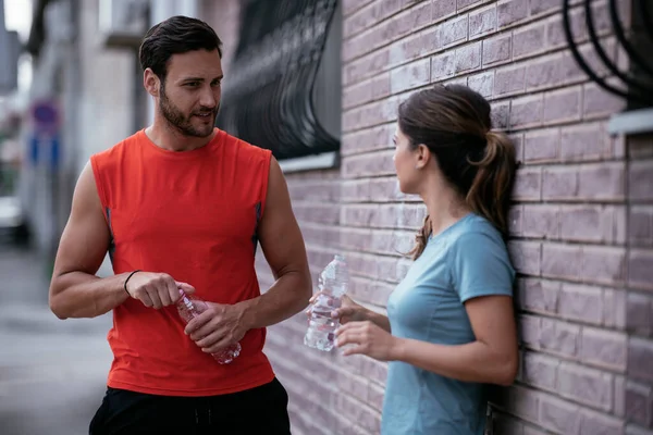 Atletik çift şehirde koştuktan sonra dinleniyor. Mutlu çift sabahları eğleniyor...