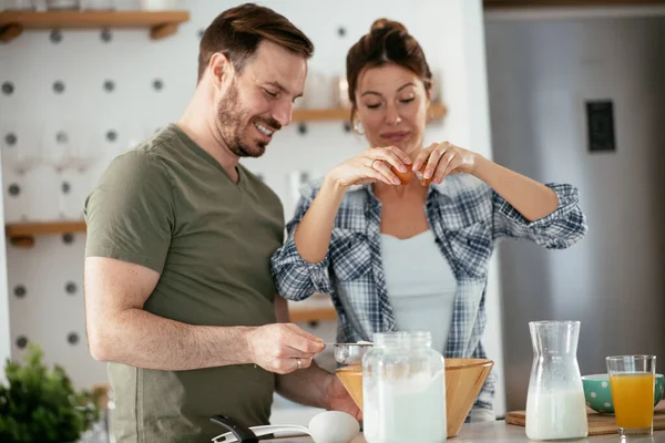 Genç çift evde krep yapıyor. Sevgili çift yemek yaparken eğleniyor..