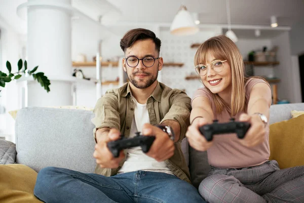 Karı koca oturma odasında joysticklerle oyun oynuyorlar. Sevgili çift evde video oyunu oynuyor..