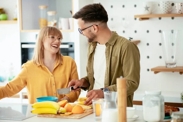 Genç çift evde kahvaltı hazırlıyor. Sevgi dolu çift mutfakta eğleniyor..