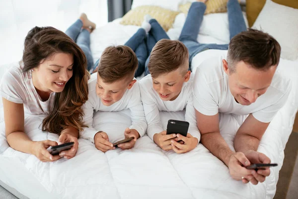 Família Usando Telefones Celulares Pais Filhos Usando Telefones Inteligentes Casa — Fotografia de Stock