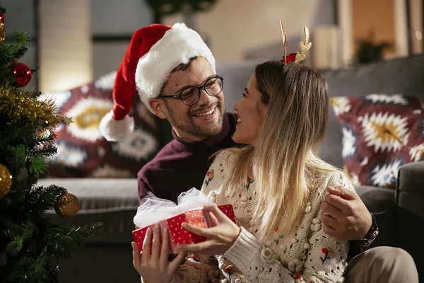 Junger Mann Überrascht Freundin Hause Mit Weihnachtsgeschenk — Stockfoto