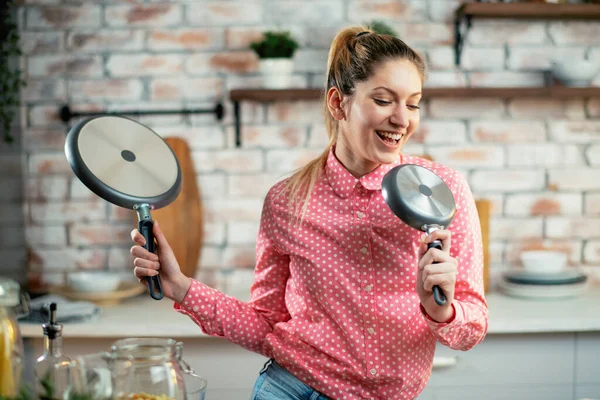 Woman singing in the kitchen. Beautiful housewife having fun while cooking.