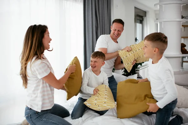 Happy family making pillow fight