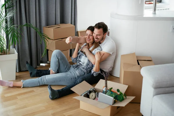 Boyfriend and girlfriend are moving in a apartment. Young couple are unpacking their belongings.