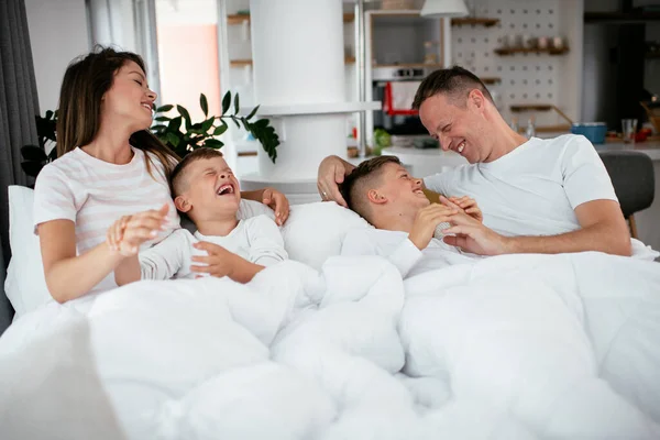 가족들은 침대에서 즐겁게 지낸다 아들들 침대에서 부모들 — 스톡 사진
