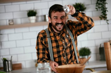 Mutfaktaki yakışıklı adamın portresi. Genç adam lezzetli yemekler hazırlıyor..