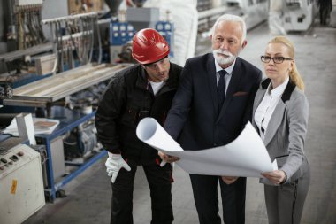 Mimarlar ve işçiler yeni projeyi planlarıyla tartışıyorlar. Fabrikada çalışan meslektaşlar..