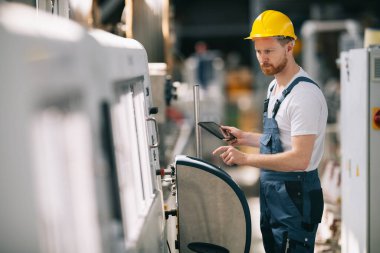 Fabrikadaki işçinin portresi. Fabrikada çalışan genç yakışıklı adam..