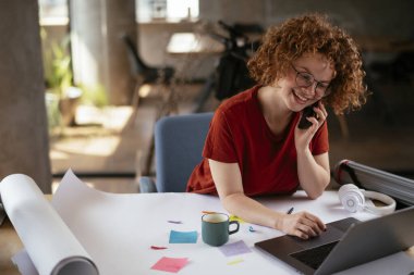 Projeler üzerinde çalışan güzel bir iş kadını. Genç iş kadını telefonda konuşuyor..