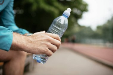 Susamış bir sporcu. Antrenmandan sonra su içen adam..