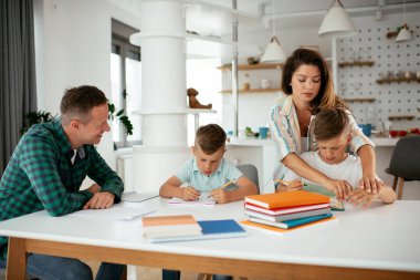 Ebeveynler çocuklara ev ödevlerinde yardım ediyorlar. Küçük çocuklar evde öğreniyor..