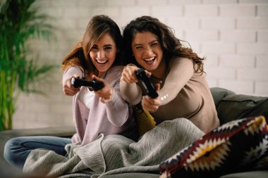 Evde video oyunu oynayan güzel genç kadınlar