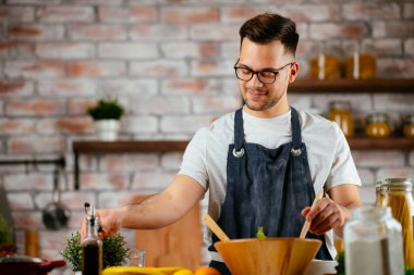 Mutfakta makarna hazırlayan yakışıklı adam. Lezzetli yemek pişiren adam..