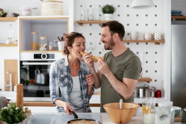 Karı koca mutfakta. Genç çift evde lezzetli yemekler hazırlıyor..