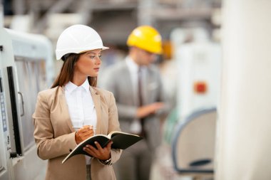 Erkek ve kadın iş tartışıyorlar. Fabrikada çalışan meslektaşlar.