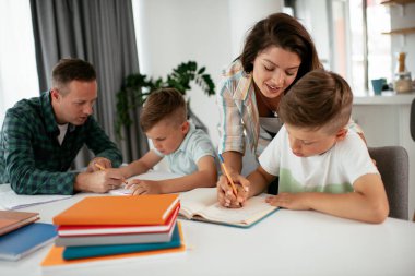 Ebeveynler çocuklara ev ödevlerinde yardım ediyorlar. Küçük çocuklar evde öğreniyor..