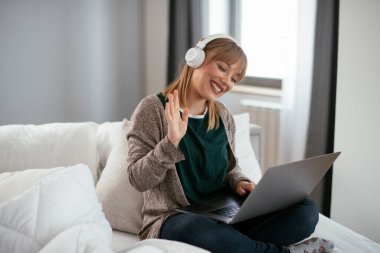 Güzel bir kadın görüntülü görüşme yapıyor. Güzel kadın evde eğleniyor..