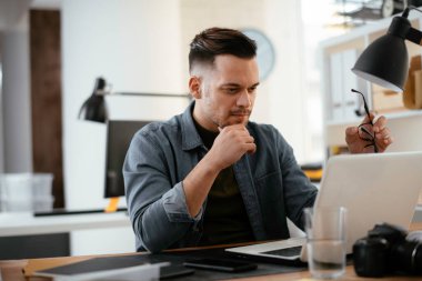 Genç işadamı ofiste çalışıyor. 