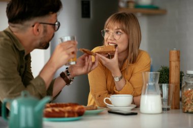 Genç çift evde lezzetli yemekler yapıyor. Sevgi dolu çift mutfakta eğleniyor..